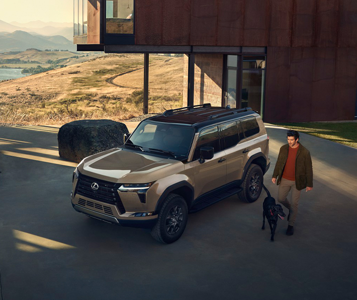 2025 Lexus GX | Man walking with his dog walking by his parked 2025 Lexus GX
