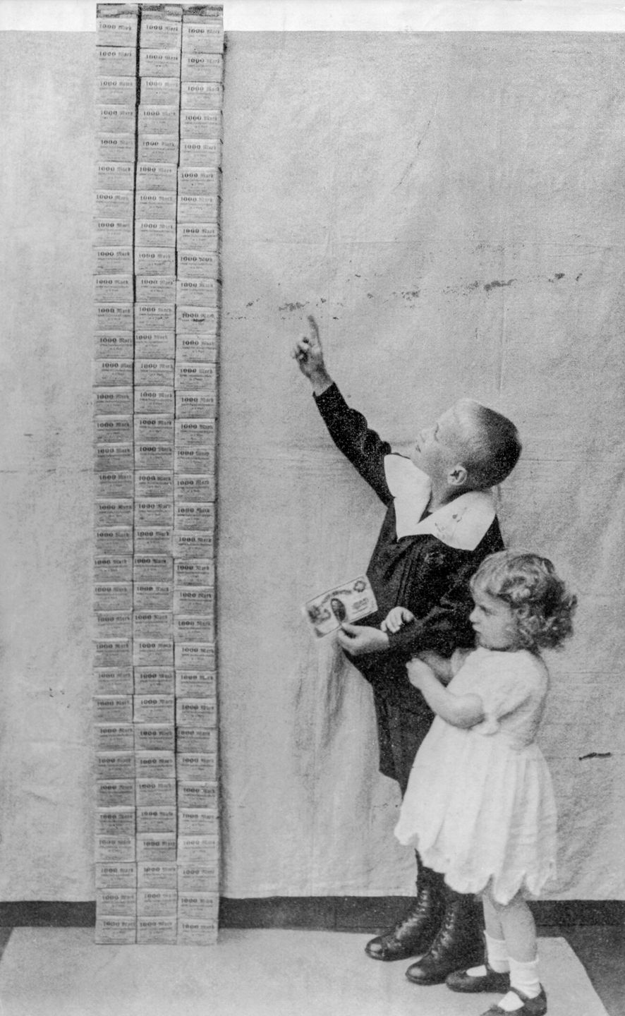 The aftermath of world war 1 - Children stand next to a tower of 100,000 marks, equal in value to one US dollar. 