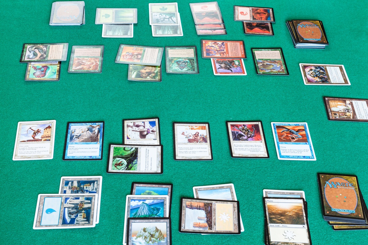 MTG cards sorted into piles on a green table showing a collection overview