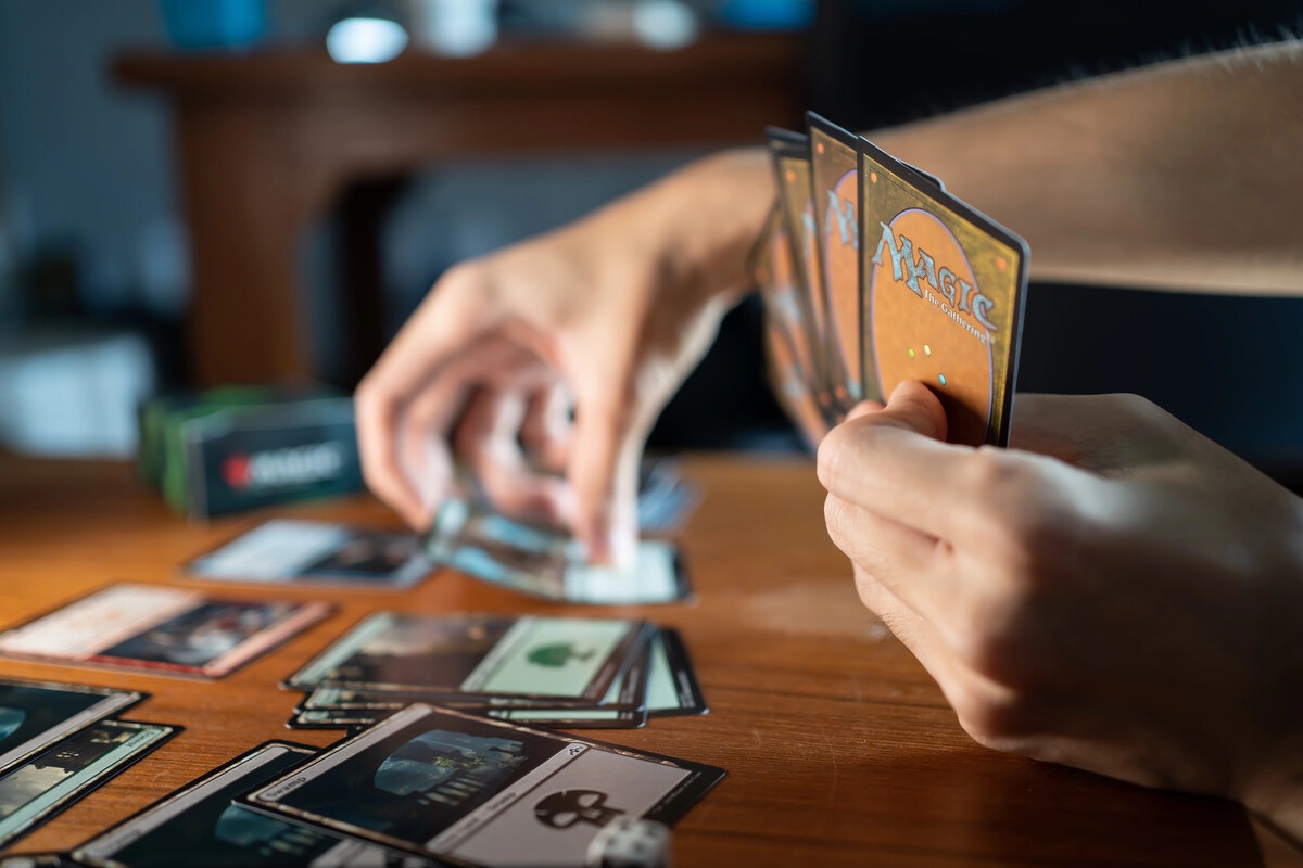 MTG hand holding cards and sorting them on a table