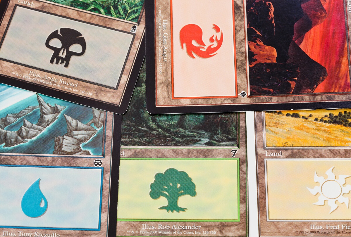 MTG land cards in closeup showing mana symbols across all five colors