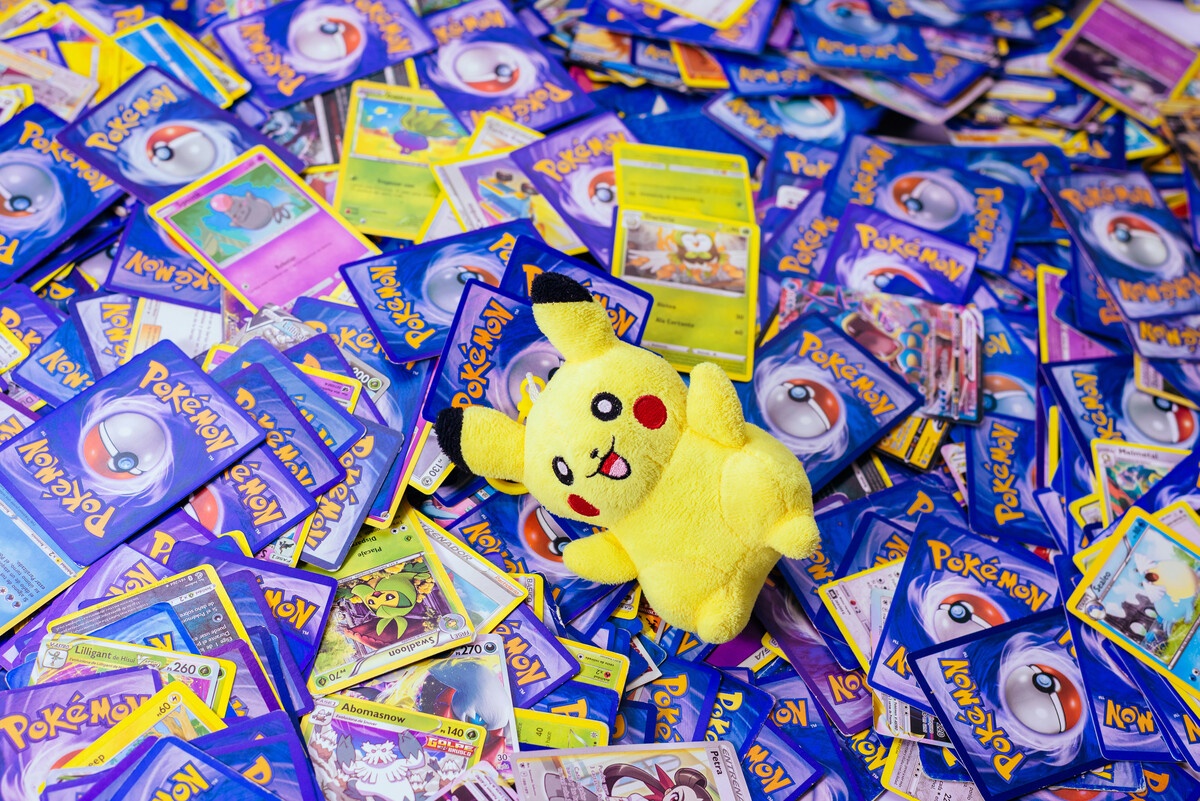 Pokemon TCG cards pile scattered with Pikachu plush evoking collection nostalgia