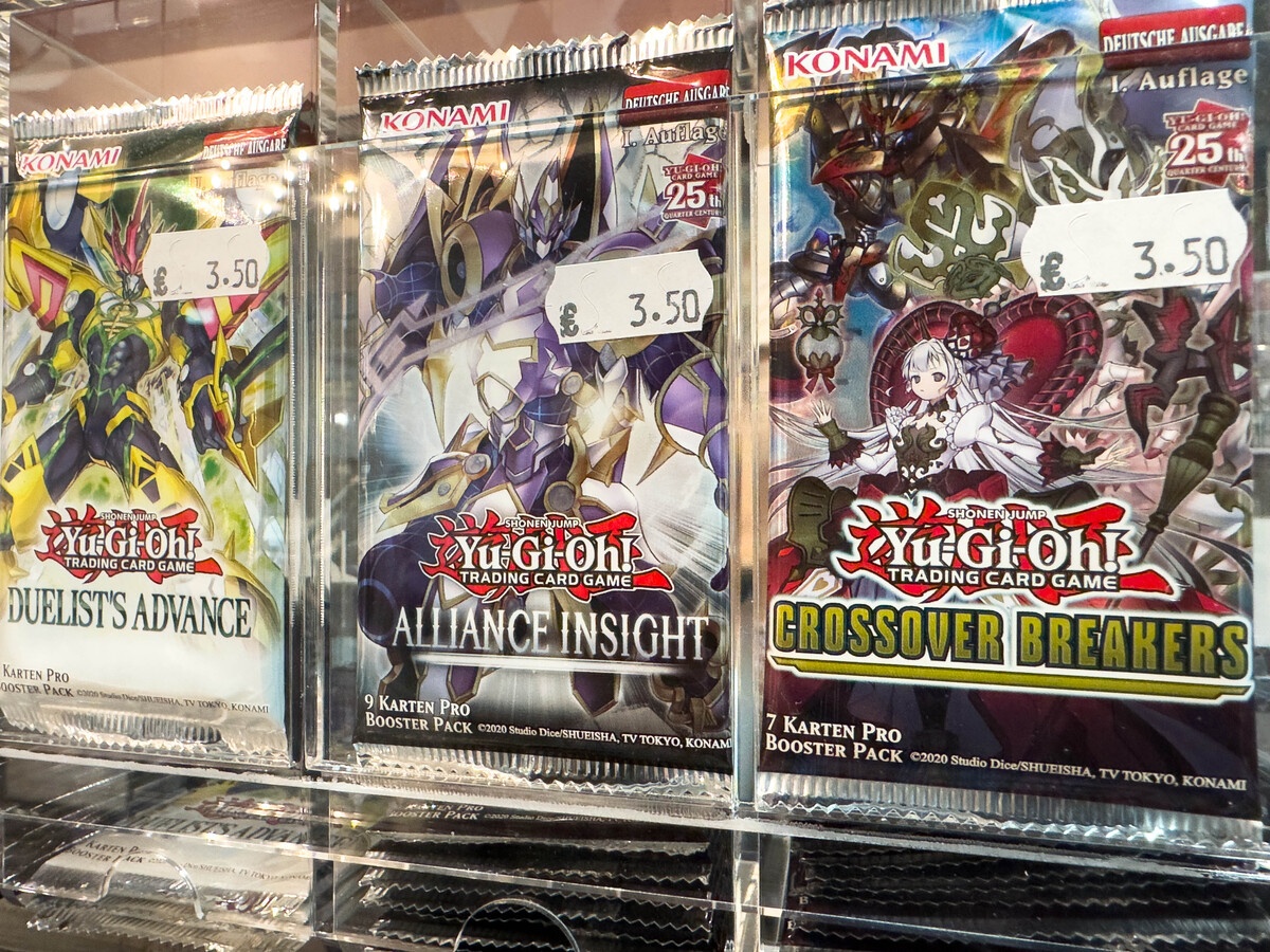 Yu-Gi-Oh booster packs on a sealed store display with Duelists Advance and Alliance sets