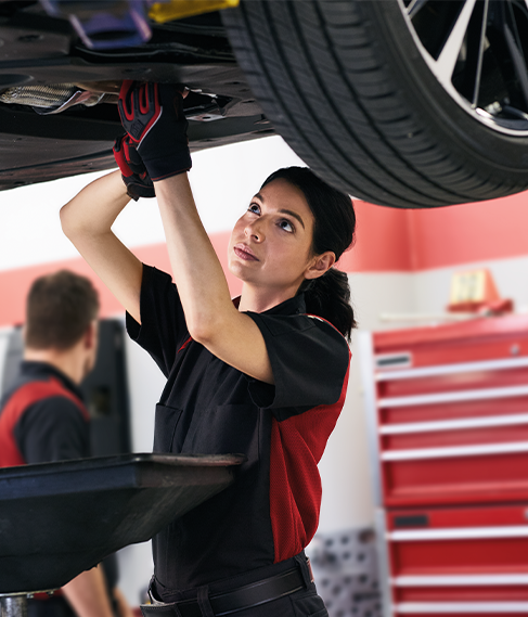 Changing your transmission fluid at CMA Toyota of Martinsburg | Toyota Mechaninc in uniform is working underneath a car doing a transmission flush 