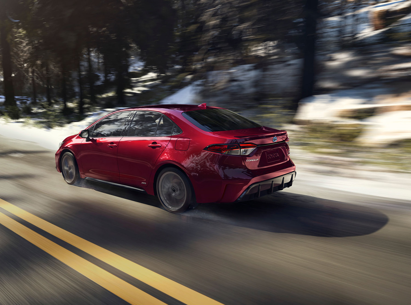 The New 2025 Toyota Corolla at Bobby Rahal Toyota in Mechanicsburg, PA | Rear profile of a 2025 Toyota Corolla driving down a road at high speeds