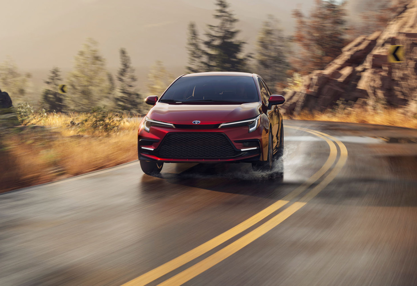 The New 2025 Toyota Corolla at Bobby Rahal Toyota in Mechanicsburg, PA | Red Toyota Corolla driving down a wet road