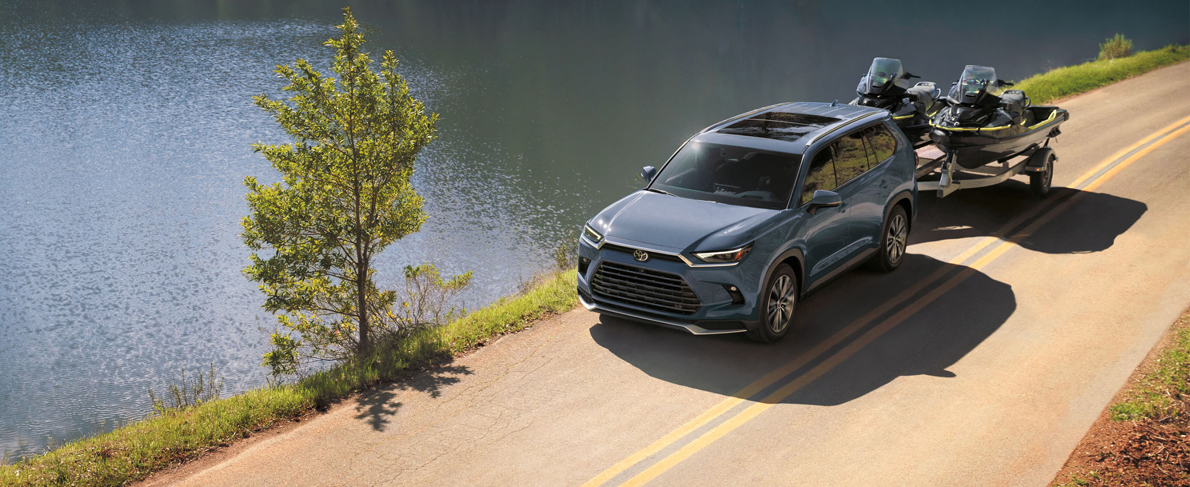 2025 Toyota Grand Highlander vs 2025 Subaru Ascent comparison | Bobby Rahal Toyota | Blue 2025 Toyota Grand Highlander towing two ski boats