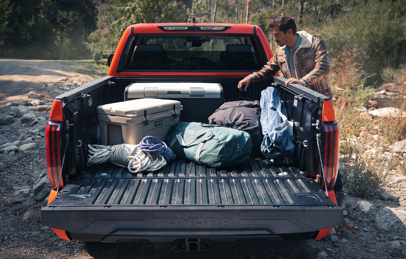The New 2025 Toyota Tundra at Bobby Rahal Toyota in Mechanicsburg, PA | Man packing up the trunk of his 2025 Toyota Tundra with bags and coolers