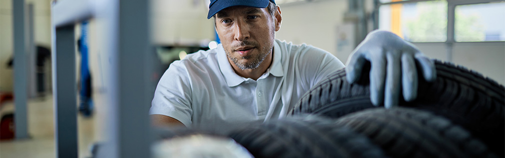 What different tire options are available at CMA's Toyota of Martinsburg | Mechanic with gloves picking out tire size