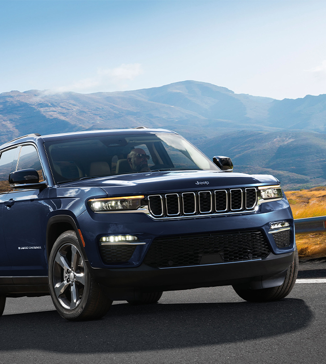 2025 Jeep Grand Cherokee at Delaney CDJR of DuBois | Blue grand cherokee driving up a hill