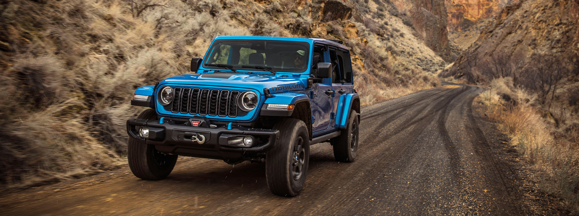 2025 Jeep Wrangler at Delaney CDJR of DuBois | Blue 2025 Jeep Wrangler driving up a dirt hill