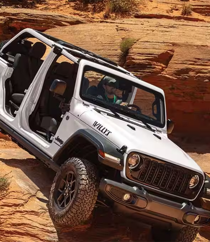 2026 Jeep Wrangler at Delaney CDJR of DuBois | White 2026 Wrangler driving down a hill
