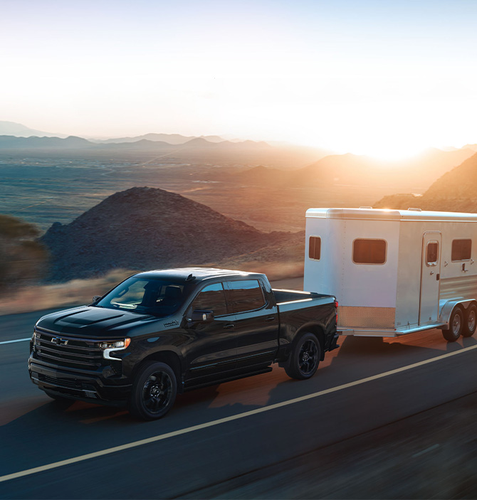 2026 Chevrolet Silverado 1500 at Delaney Chevrolet of Greensburg | Black 2026 Silverado towing a white camper up a hill 2026 Chevrolet Silverado 1500 at Delaney Chevrolet of Greensburg | Black 2026 Silverado towing a white camper up a hill