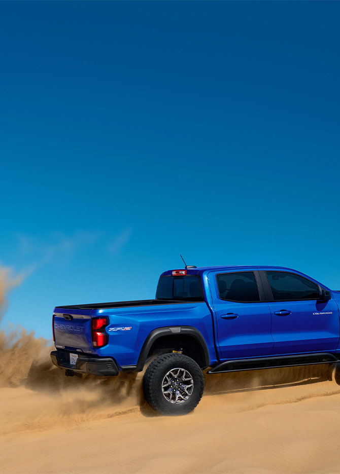 2026 Chevrolet Colorado at Delaney Chevrolet of Greensburg | Rear profile of a 2026 Chevrolet Colorado driving in the sand 2026 Chevrolet Colorado at Delaney Chevrolet of Greensburg | Rear profile of a 2026 Chevrolet Colorado driving in the sand