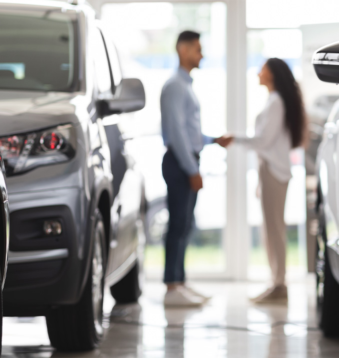Things to Check When Buying a Used Car | Delaney Chevrolet of Greensburg in Greensburg, PA | Sales person shaking hands with client inside of dealership