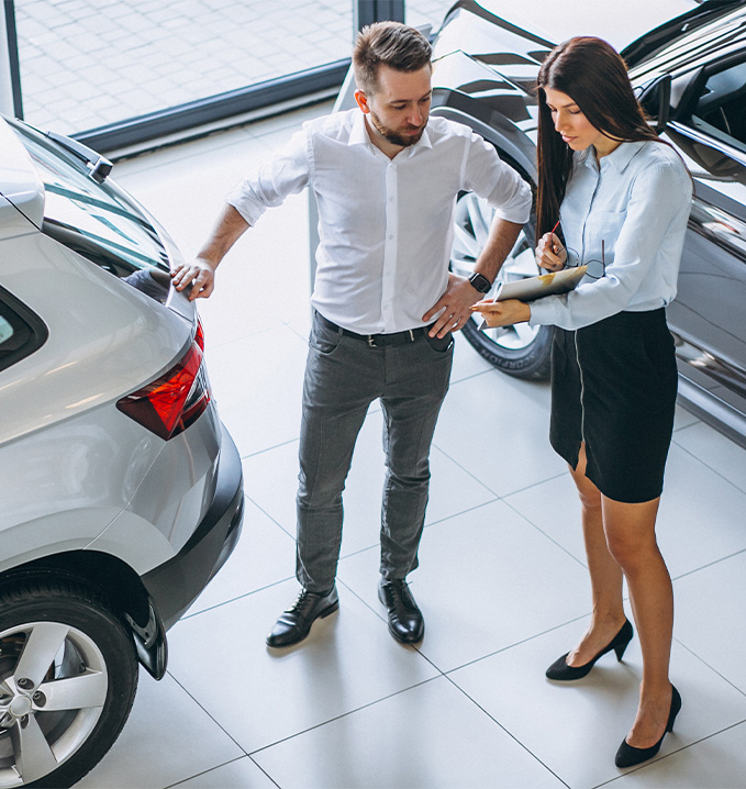 Things to Check When Buying a Used Car | Delaney Chevrolet of Greensburg in Greensburg, PA | Sales person showing customer a clipboard of all the used car information