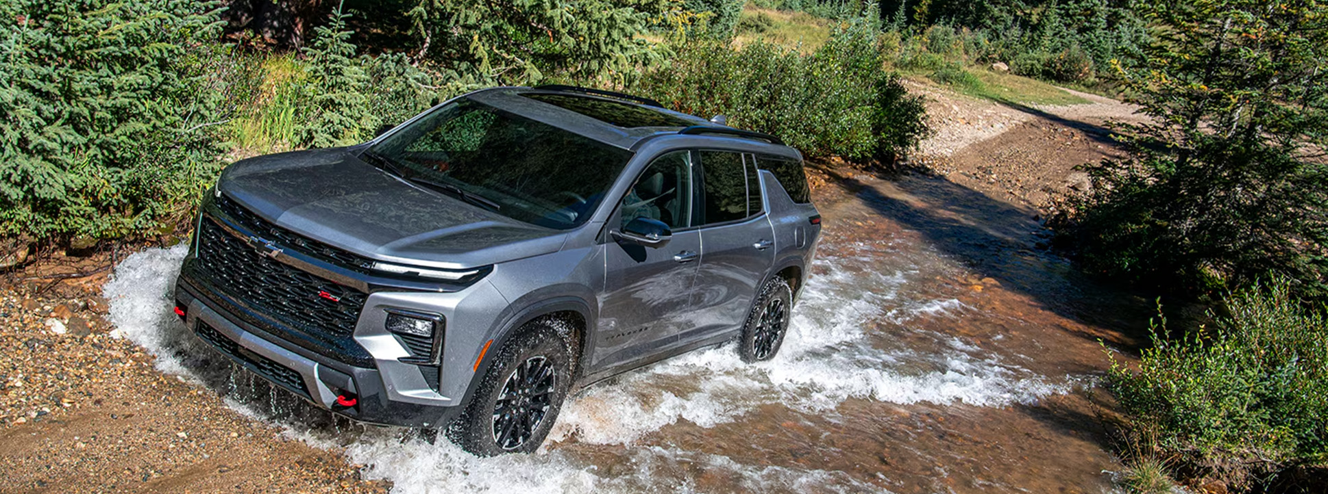 2026 Chevrolet Traverse at Delaney Chevrolet of Indiana | 2026 Chevrolet Traverse driving up a hill with a small water puddle