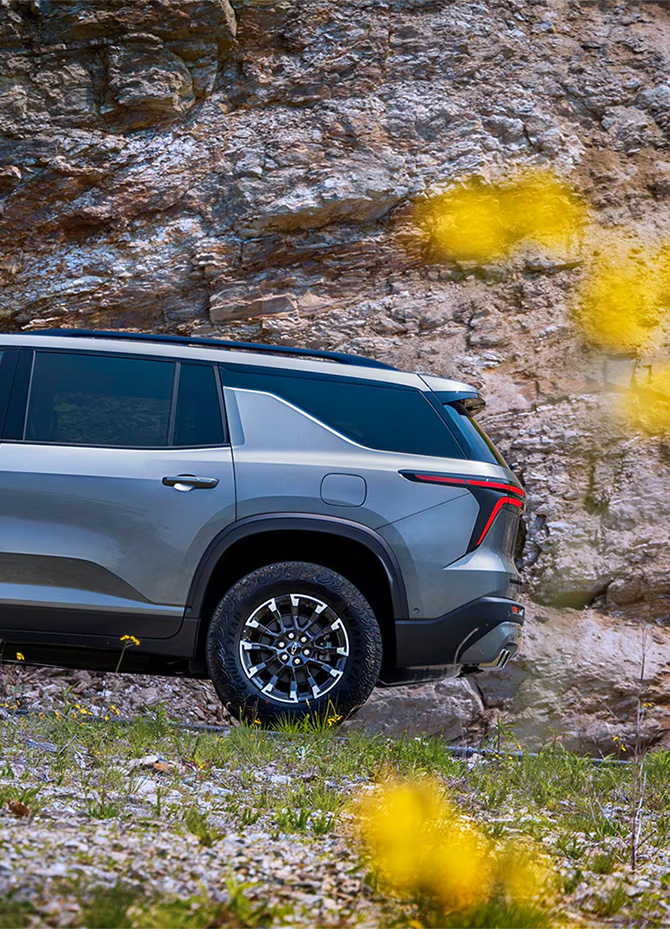 2026 Chevrolet Traverse at Delaney Chevrolet of Indiana | Rear profile of a silver 2026 Chevrolet Traverse driving up a hill