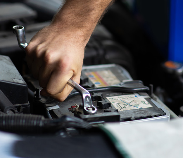 Everything You Need to Know about Your Car Battery at Delaney Chevrolet of Indiana |  Person using a hand tool to tighten the battery cable bolt 