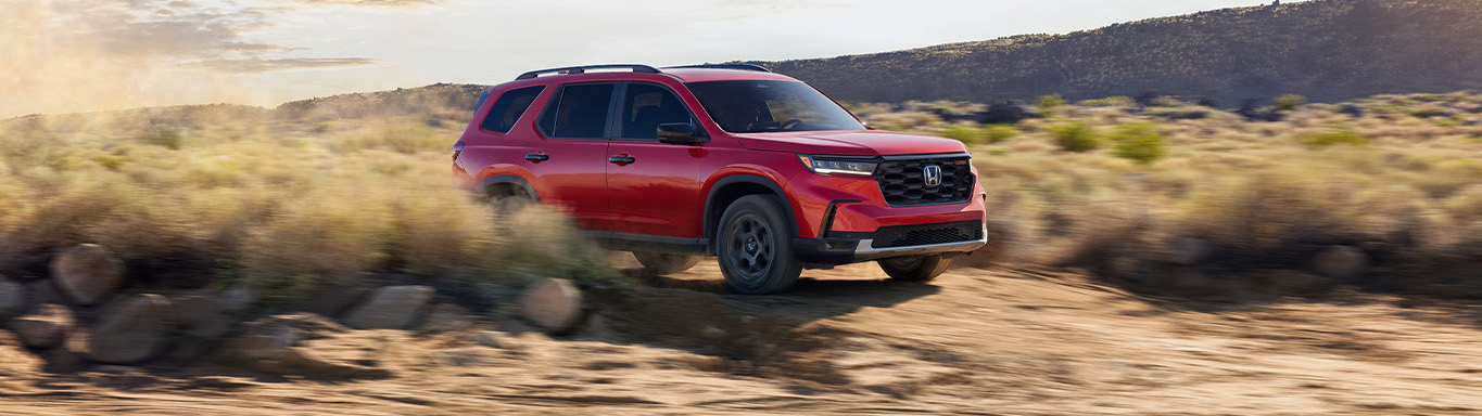 New 2025 Honda Pilot at Delaney Honda | Red 2025 Honda Pilot driving off-road New 2025 Honda Pilot at Delaney Honda | Red 2025 Honda Pilot driving off-road