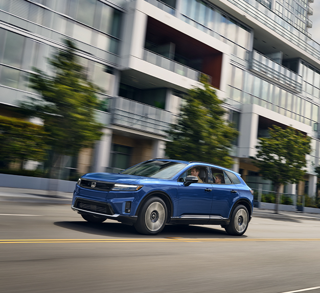 New 2025 Honda Prologue at Delaney Honda | Dark blue 2025 Honda Prologue driving down a street at high speeds