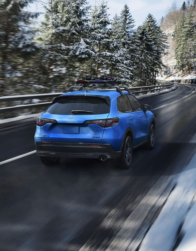 New 2026 Honda HR-V at Delaney Honda | Rear profile of a blue 2026 Honda HR-V driving down a road during the winter New 2026 Honda HR-V at Delaney Honda | Rear profile of a blue 2026 Honda HR-V driving down a road during the winter