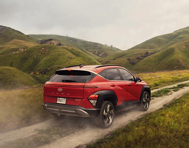  2026 Hyundai Kona at Delaney Hyundai of Dubois | Rear profile of a 2026 Hyundai Kona driving down an off-road road with views of the mountains in the back