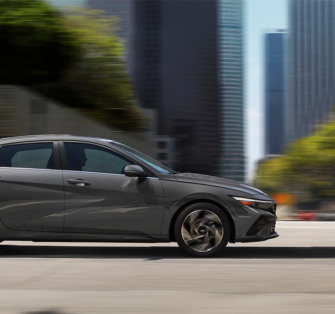  2026 Hyundai Elantra at Delaney Hyundai of Indiana | Side profile of a 2026 Hyundai Elantra driving down the street