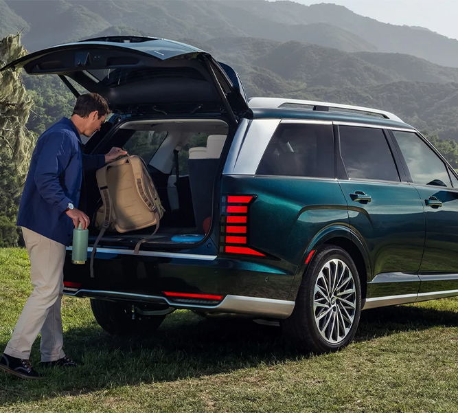 All-New 2026 Hyundai Palisade at Delaney Hyundai of Indiana | Man putting his backpack in the trunk of a 2026 Hyundai Palisade