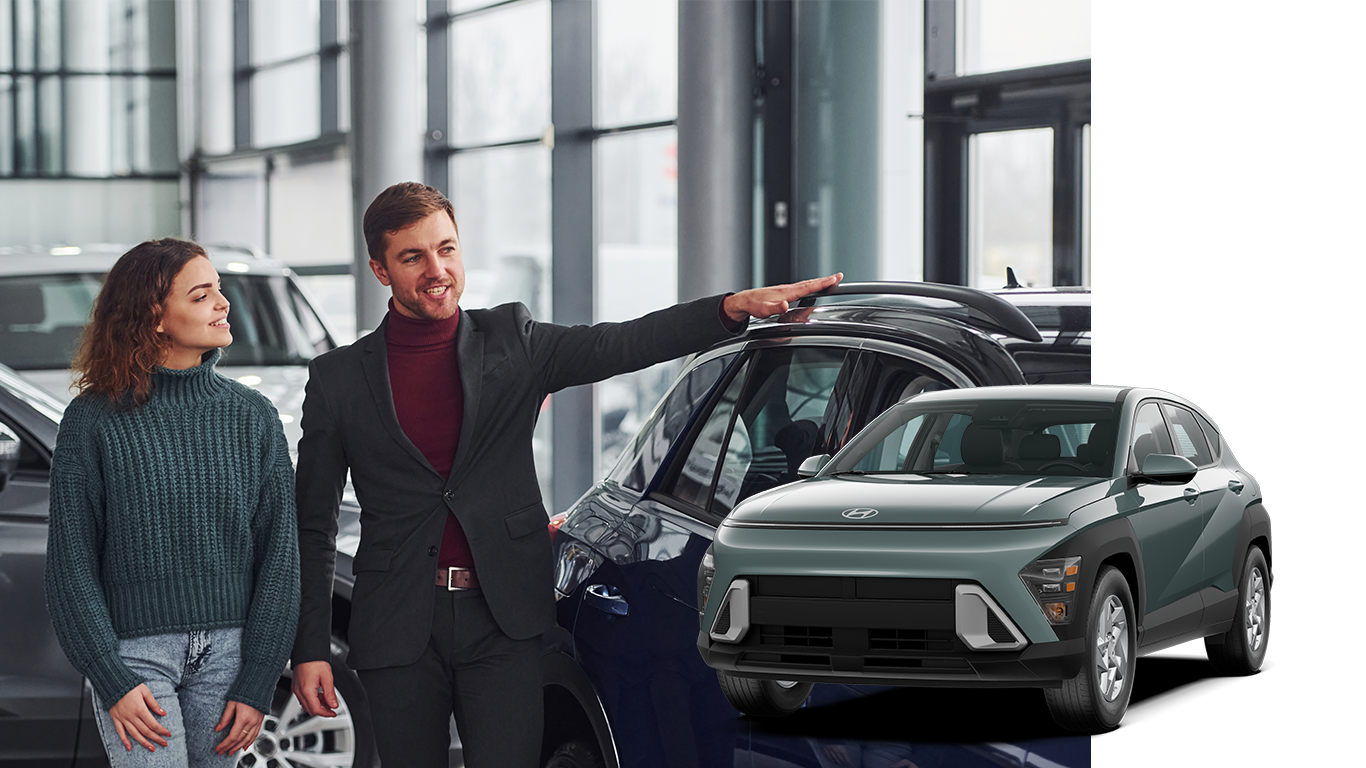 Best Time To Buy At Delaney Hyundai of Indiana in Indiana, PA | Sales person showing customer a selection of new cars in dealership / 2024 Hyundai Kona in the color green