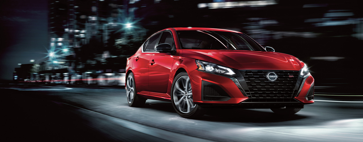 2025 Nissan Altima at Delaney Nissan of Greensburg | Red 2025 Nissan Altima driving down a city street