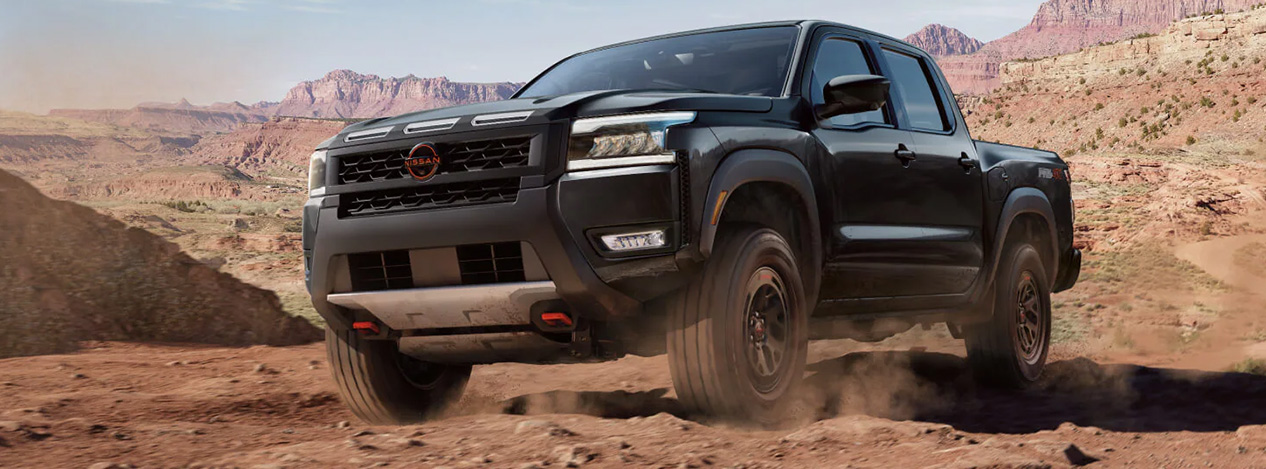 2025 Nissan Frontier at Delaney Nissan of Greensburg | Black 2025 Nissan Frontier driving through the desert 2025 Nissan Frontier at Delaney Nissan of Greensburg | Black 2025 Nissan Frontier driving through the desert