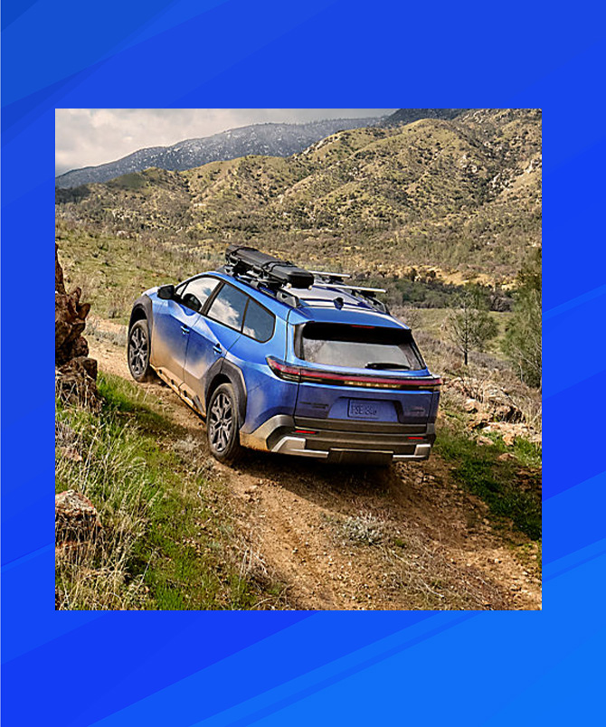 2026 Subaru Trailseeker EV at Delaney Subaru in Indiana, PA | Rear profile of a 2026 Subaru TrailSeeker EV driving up a hill 2026 Subaru Trailseeker EV at Delaney Subaru in Indiana, PA | Rear profile of a 2026 Subaru TrailSeeker EV driving up a hill
