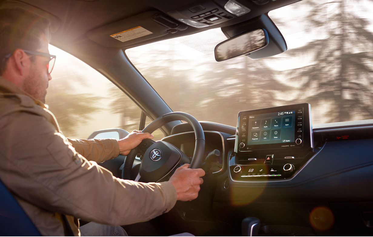 The New 2025 Toyota Corolla at Delaney Toyota of DuBois in DuBois, PA | Man with glasses driving his 2025 Toyota Corolla with both hands on the steering wheel
