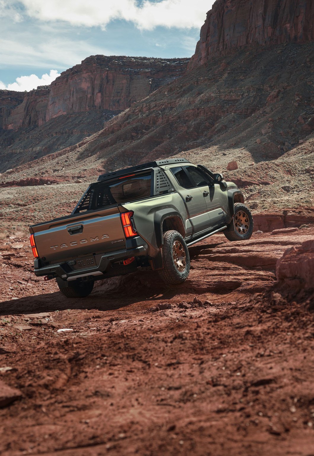 2025 Toyota Tacoma at Delaney Toyota of DuBois in DuBois, PA | Rear profile of a 2025 Toyota Tacoma driving up a hill