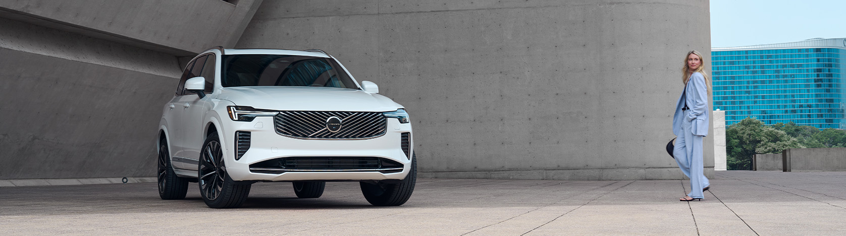 2026 Volvo XC90 | Woman in blue suit walking up to her white 2026 Volvo XC90 2026 Volvo XC90 | Woman in blue suit walking up to her white 2026 Volvo XC90