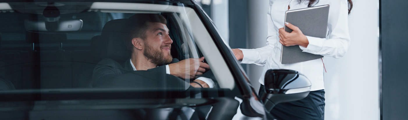Sell us your car | Man in car handing over car keys to sales representative in white shirt Sell us your car | Man in car handing over car keys to sales representative in white shirt