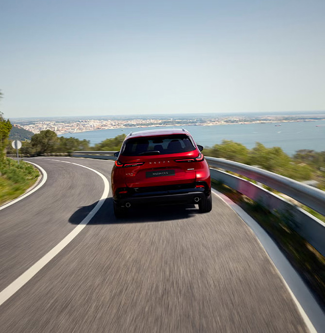 2026 Mazda CX-5 at Lancaster Mazda | Rear profile of a 2026 Mazda CX-5 driving down a hill 2026 Mazda CX-5 at Lancaster Mazda | Rear profile of a 2026 Mazda CX-5 driving down a hill