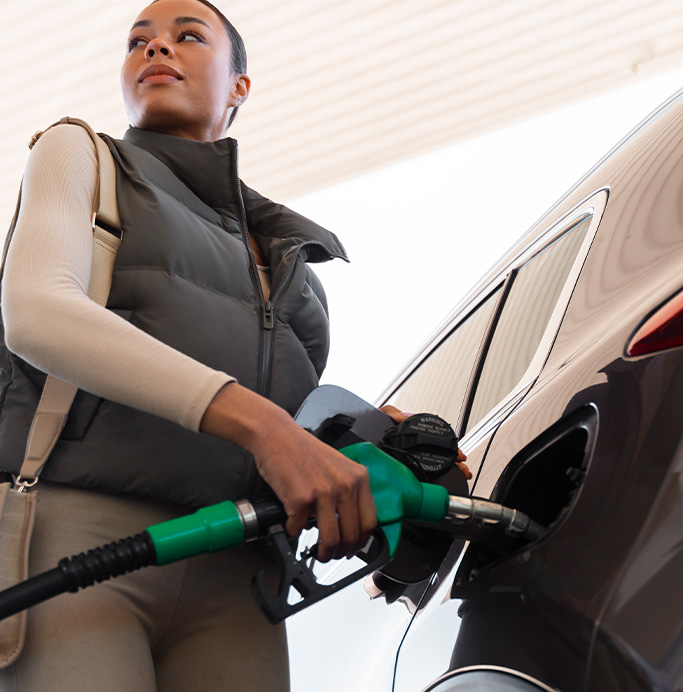 What Type of Gas is Best for My Car? | Lancaster Mazda in East Petersburg, PA | Woman putting gas nozzle in to her car