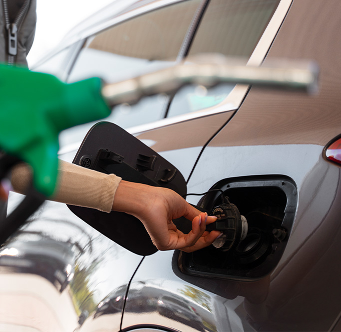 What Type of Gas is Best for My Car? | Lancaster Mazda in East Petersburg, PA | woman tightening gas cap after putting gas into car