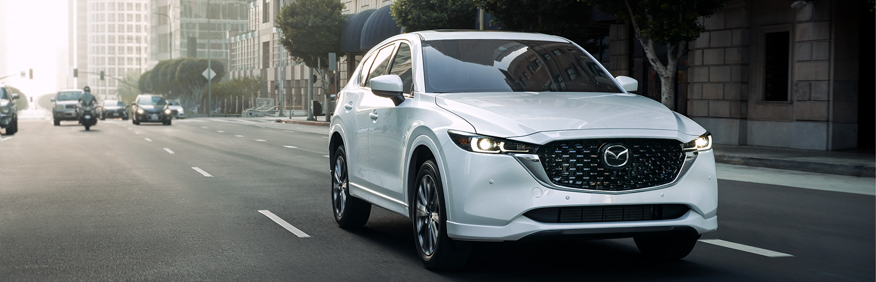 Why Buy a Mazda at Lancaster Mazda in East Petersburg, PA | White 2024 Mazda CX-5 driving down the city street