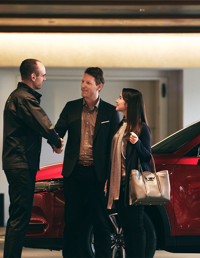 Why Buy a Mazda at Lancaster Mazda in East Petersburg, PA | Mazda Sales person shaking hands with customers inside of dealership