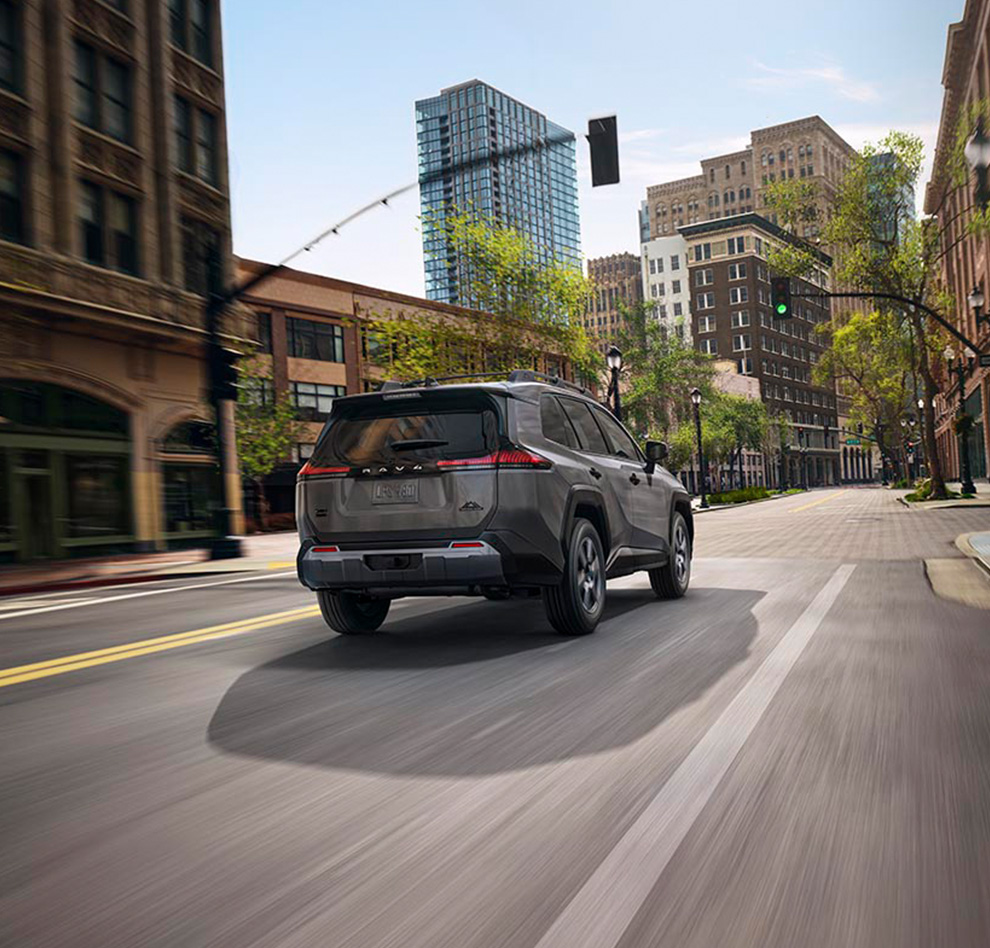 2026 Toyota RAV4 at Lancaster Toyota in East Petersburg, PA | Rear profile of a 2026 Toyota RAV4 driving down a city street 2026 Toyota RAV4 at Lancaster Toyota in East Petersburg, PA | Rear profile of a 2026 Toyota RAV4 driving down a city street