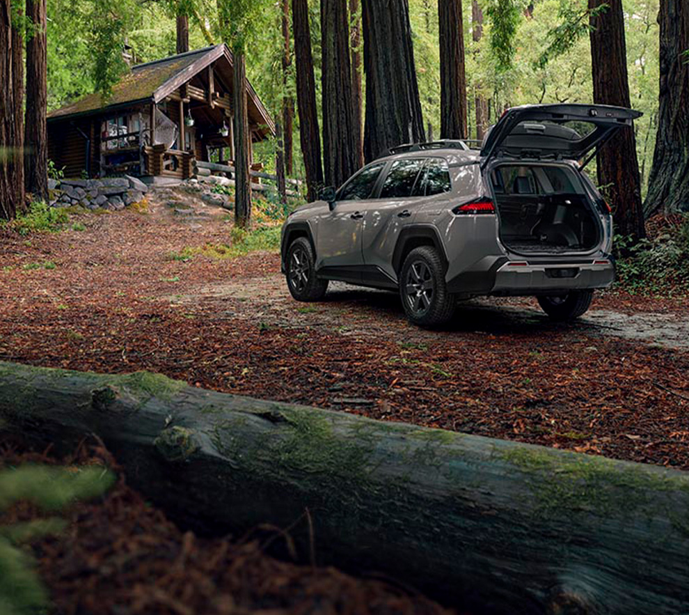 2026 Toyota RAV4 at Lancaster Toyota in East Petersburg, PA | 2026 Toyota RAV4 parked in front of a cabin with the trunk open 2026 Toyota RAV4 at Lancaster Toyota in East Petersburg, PA | 2026 Toyota RAV4 parked in front of a cabin with the trunk open
