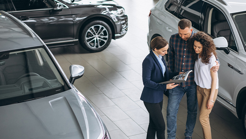 The Advantages of Buying a Car from a Dealership vs. a Private Seller. Learn more at Mechanicsville Toyota in Mechanicsville, VA | Sales person showing a couple the paper work for their new vehicle