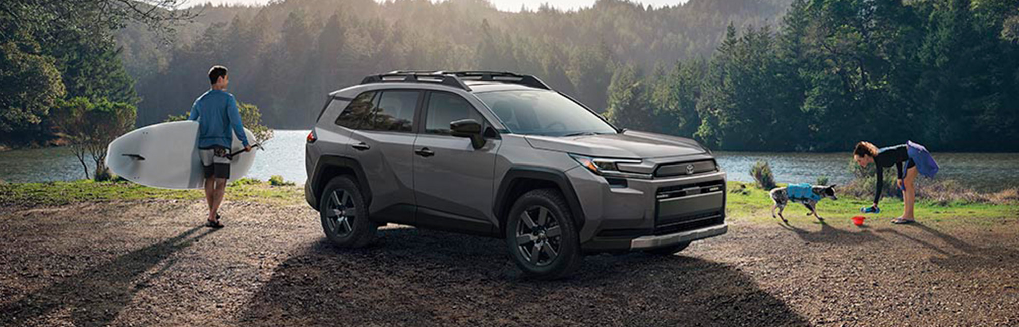 2026 Toyota RAV4 at Palmiero Toyota in Meadville, PA | New 2026 Toyota RAV4 parked by a lake with a man walking with his surfboard
