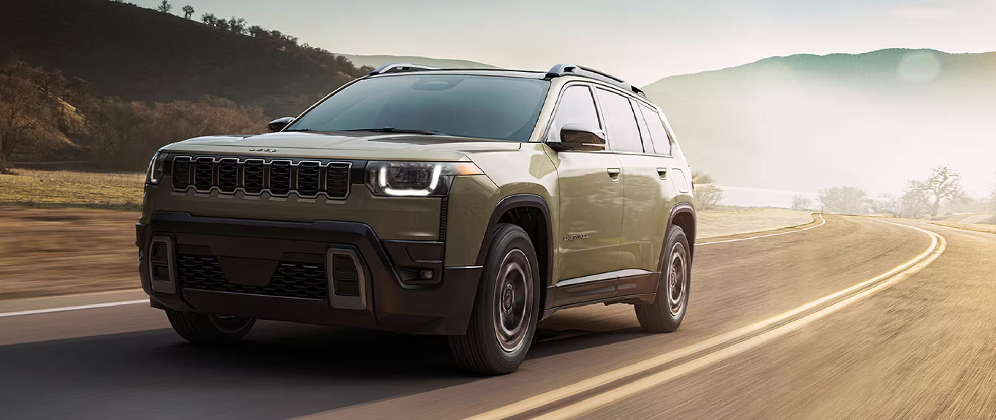 2026 Jeep Cherokee at CMA's CDJR of Martinsburg | Green 2026 Jeep Cherokee driving down an empty road
