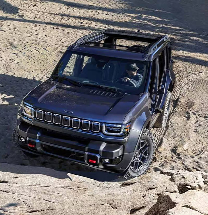 2026 Jeep Recon at Delaney CDJR of DuBois | Man driving his grey color 2026 Jeep Recon up a hill