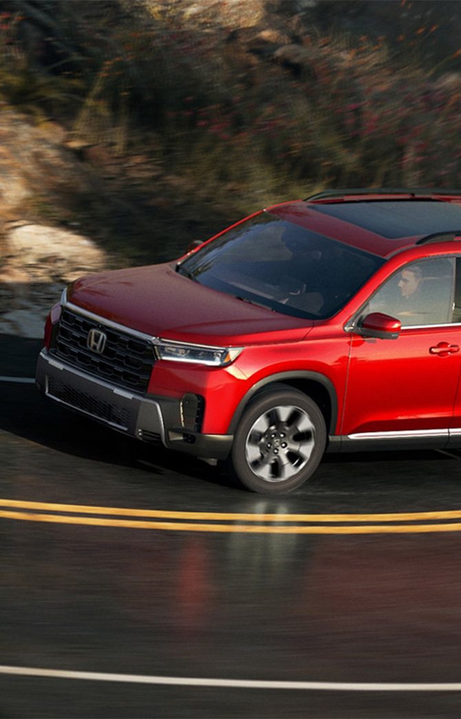 New 2026 Honda Pilot at Delaney Honda | Red 2026 Honda Pilot driving up the road New 2026 Honda Pilot at Delaney Honda | Red 2026 Honda Pilot driving up the road