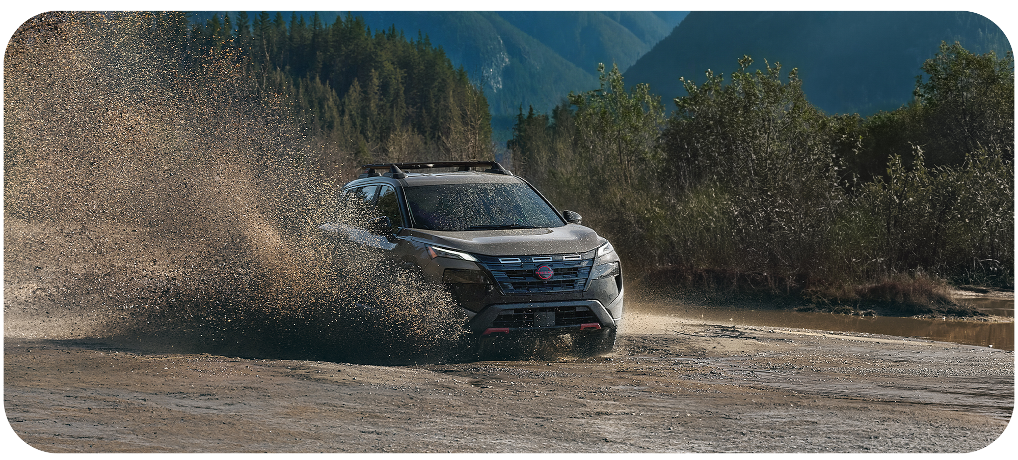 2026 Nissan Rogue vs. 2026 Honda CR-V vs. 2026 Toyota RAV4 at Delaney Nissan of Greensburg in Greensburg, PA | Dark color 2026 Nissan Rogue driving through the mud